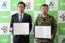 協定書を持ち記念写真に写る加藤市長と藤田司令