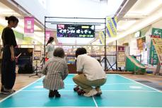 参加者(左)にボッチャのレクチャーをする学生(右)