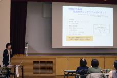 スクリーンの資料を見ながら講演を聞く参加者