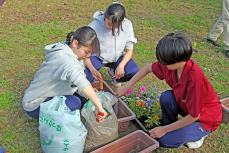 土を入れる高校生